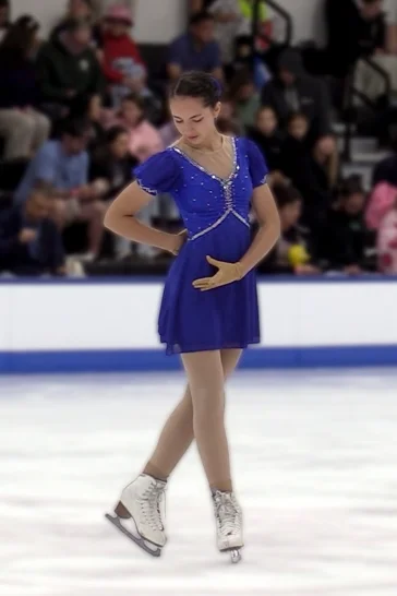 Mikayla skating in a blue competition dress